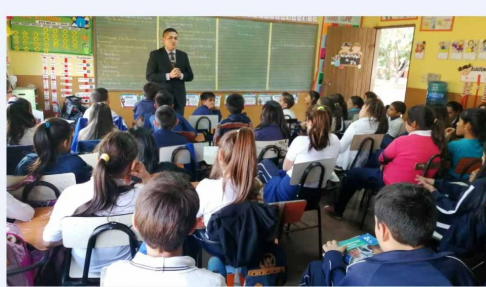 El abogado Blas Figueredo, juez de Paz de Capiatá, durante la charla con niños y niñas de la Escuela San Miguel.